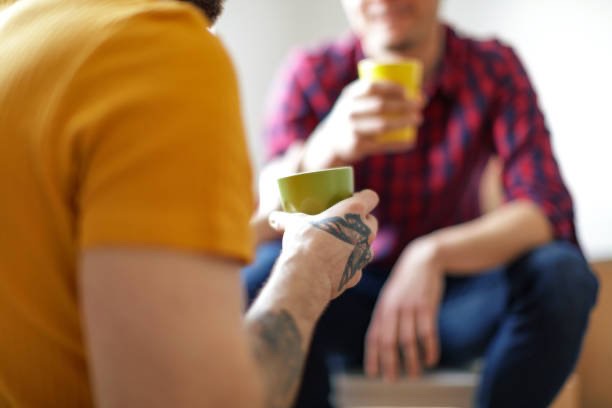 Twee mensen drinken samen koffie en praten. Tijd en aandacht, van mens tot mens.